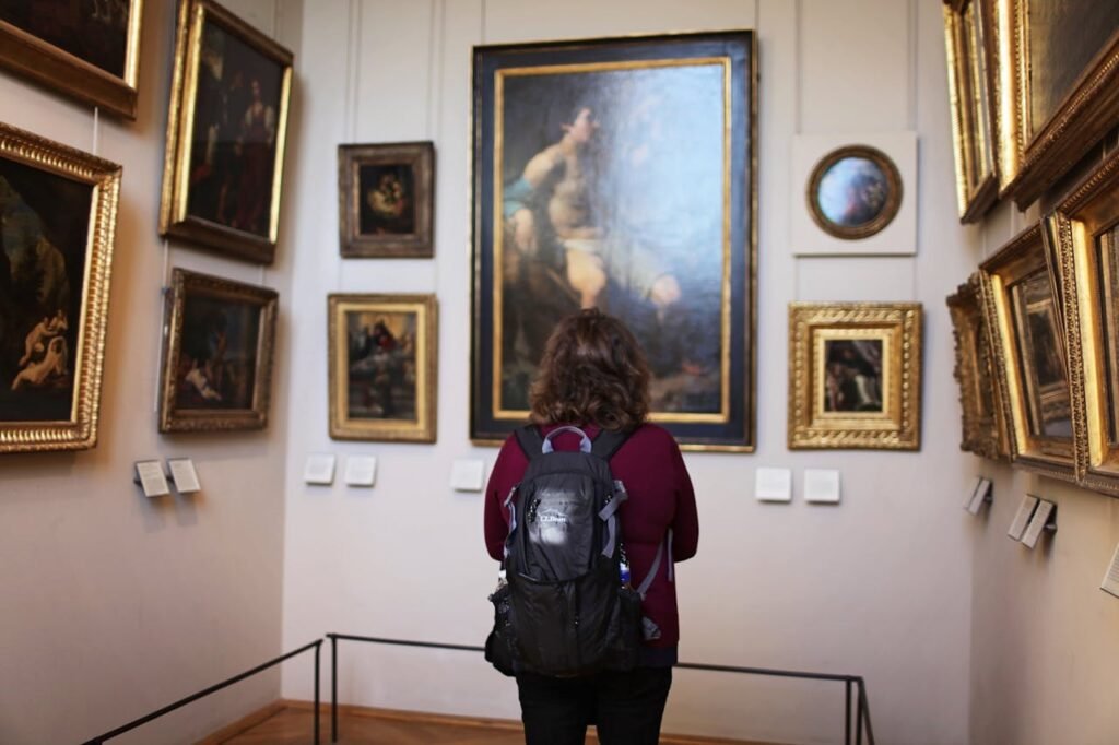 pexels-photo-952588 Woman Standing In front Of Paintings